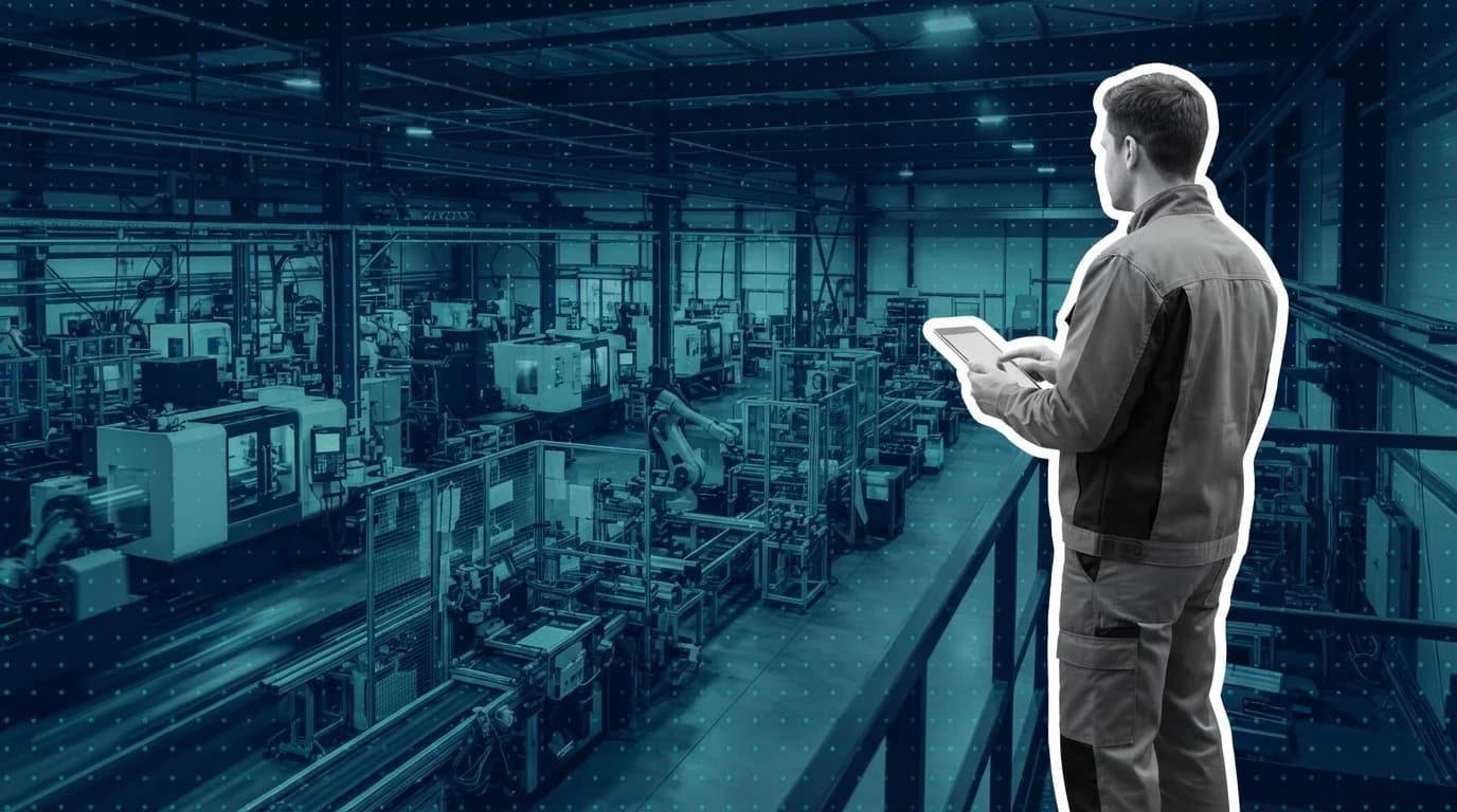 Plant manager overlooking an active production line from an elevated walkway with a tablet in hand